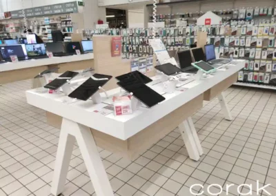 Table multimédia présentant des tablettes et des laptops d'un rayon Auchan